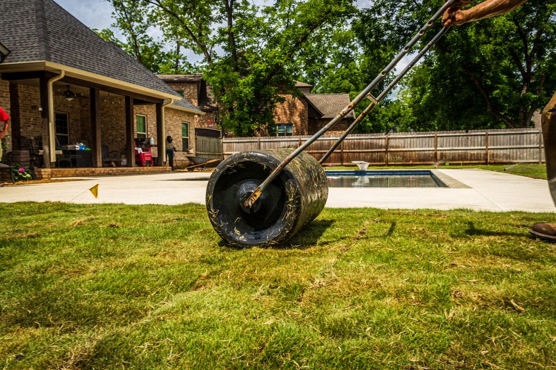 Worker rolling fresh sod to install a new lawn
